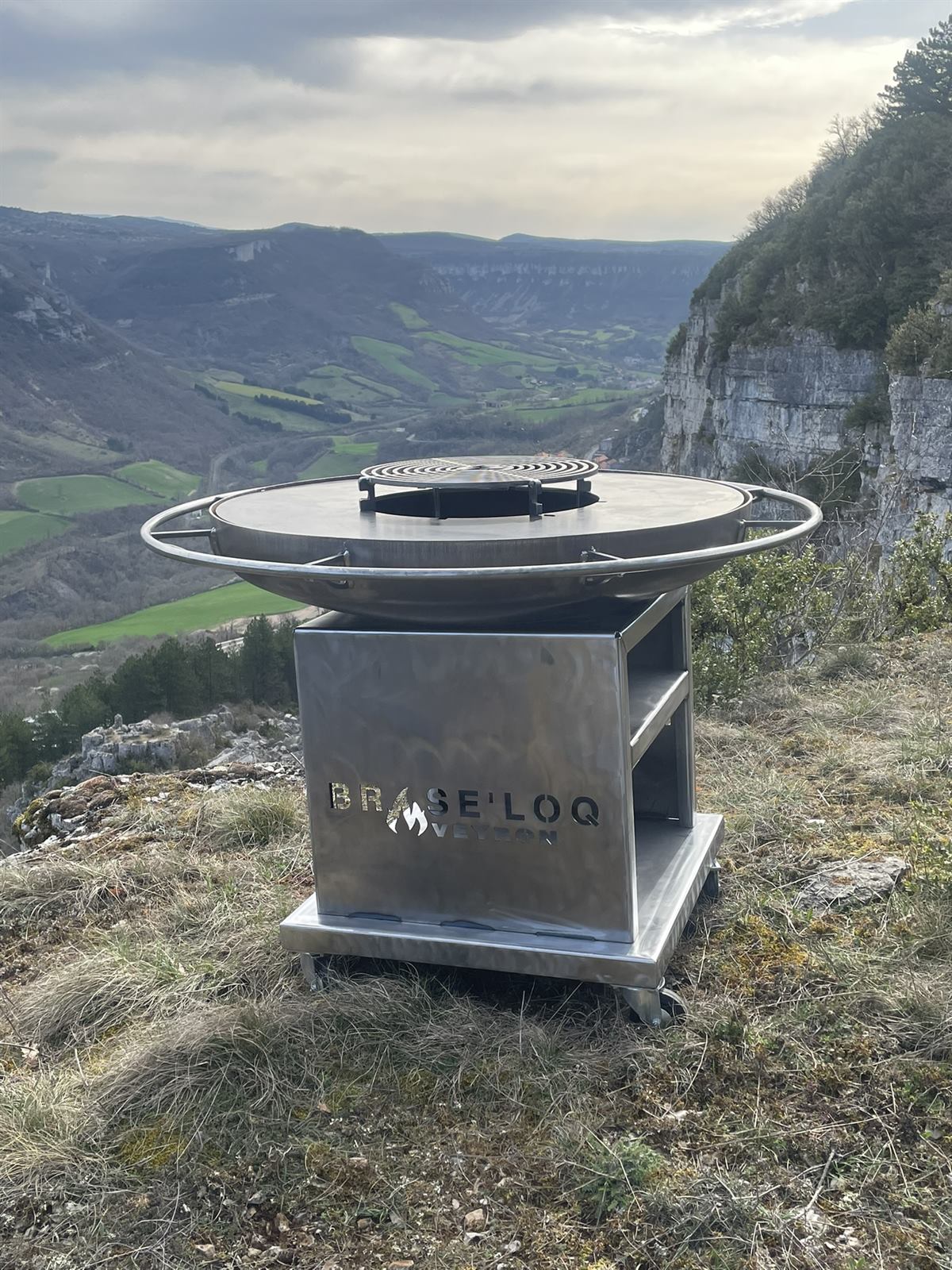 Brasero Brasé'Roq en acier brut posé face aux causses de l'Aveyron